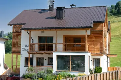 a wooden house with a metal roof at Chalet Lumis in San Vigilio Di Marebbe