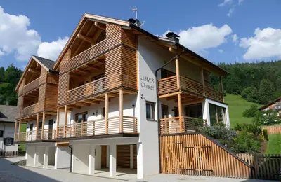 a building with wooden balconies on the side of it at Chalet Lumis in San Vigilio Di Marebbe