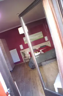 a view of a room with a bed and a mirror at Garni Villa Betty in Merano