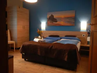 a bedroom with a large bed with blue walls at Garni Villa Betty in Merano