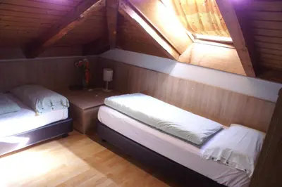 two beds in a small room with a window at Garni Villa Betty in Merano
