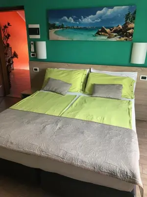 a bed with yellow sheets and pillows in a bedroom at Garni Villa Betty in Merano