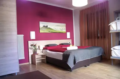 a bedroom with a bed with a red wall at Garni Villa Betty in Merano