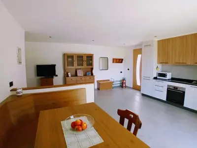 a kitchen with a table with a bowl of fruit on it at Appartamento Miele di Pino in Ziano di Fiemme