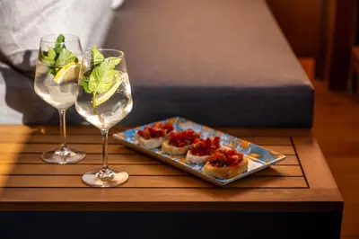 a table with two wine glasses and a plate of food at La Munt in Longega