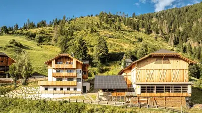a group of houses on a hill with a mountain at La Munt in Longega