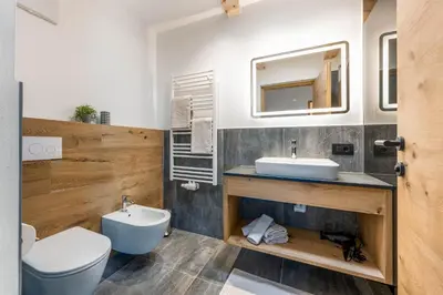 a bathroom with a sink and a toilet and a mirror at La Munt in Longega