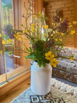 a white vase filled with flowers on a table at Chalet Cermis in Cavalese