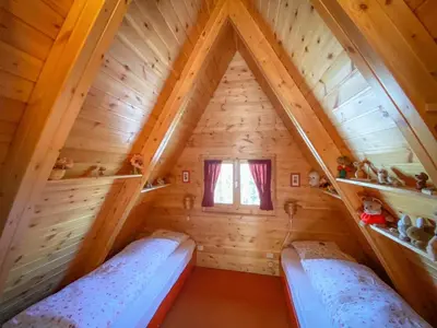 two beds in the attic of a log cabin at Chalet Cermis in Cavalese