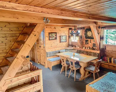a dining room in a log cabin with a table and chairs at Chalet Cermis in Cavalese