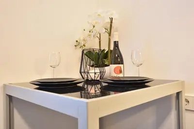 a table with two plates and a bottle of wine at Cosy new apartment in calm area near merano in Merano