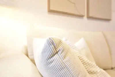 a white couch with two pillows on it at Cosy new apartment in calm area near merano in Merano