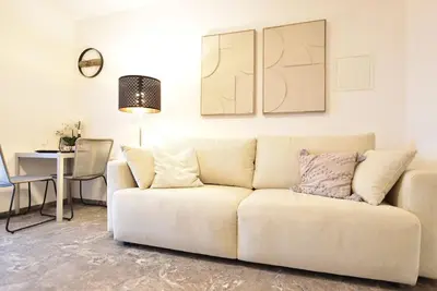 a living room with a white couch and a table at Cosy new apartment in calm area near merano in Merano