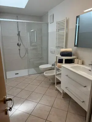 a bathroom with a shower and a toilet and a sink at Öhlers Prime Suite in Vipiteno