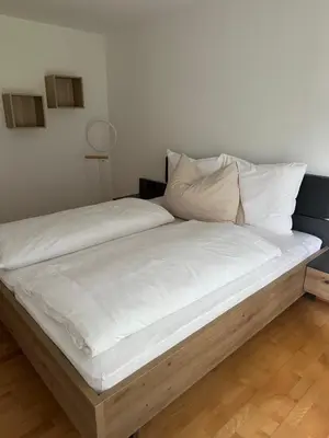 a large bed with white sheets and pillows at Öhlers Prime Suite in Vipiteno