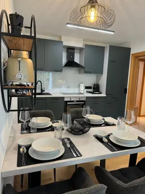 a kitchen with a table with plates and glasses on it at Öhlers Prime Suite in Vipiteno