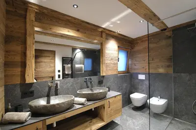 two sinks in a bathroom with wooden walls at Chalet Roderer in Laion
