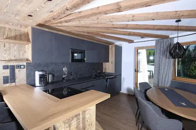 a kitchen with a wooden counter top and a table at Chalet Roderer in Laion