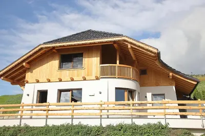 a house with a wooden roof on top of it at Chalet Roderer in Laion