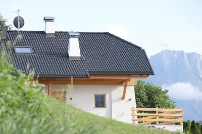 a house with a black roof on top of a hill at Chalet Roderer in Laion