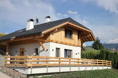 a house with a wooden fence in front of it at Chalet Roderer in Laion