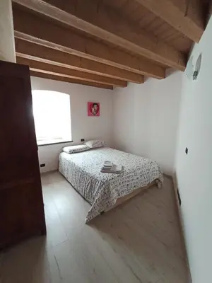 a bedroom with a bed and a large window at Appartamento Lorena a Mezzano in Mezzano