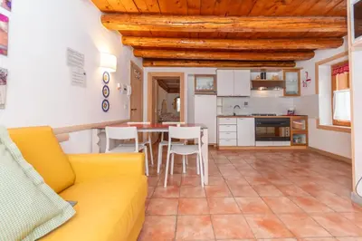 a living room with a yellow couch and a table at Casa Alessandra in Falcade