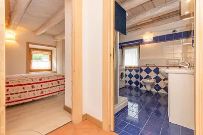 a bathroom with a bed and a sink and a toilet at Casa Alessandra in Falcade