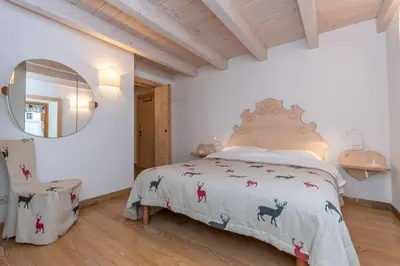 a bedroom with a bed with a bedspread with animals on it at Casa Alessandra in Falcade
