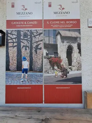 a large poster on the side of a building with two children playing at Casa Dolomiti in Mezzano