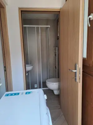 a bathroom with a toilet and a glass shower door at Casa Dolomiti in Mezzano