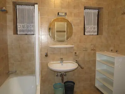 a bathroom with a sink and a tub and a mirror at Larjëi in San Cassiano