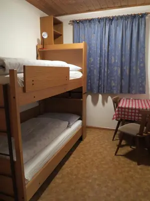 a bedroom with two bunk beds and a window at Larjëi in San Cassiano