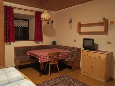 a small room with a table and a tv at Larjëi in San Cassiano