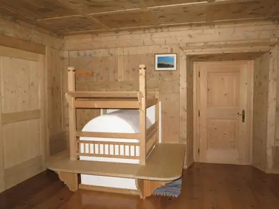 a wooden room with a bunk bed in it at Larjëi in San Cassiano