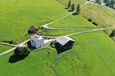 an aerial view of a house on a green field at Larjëi in San Cassiano