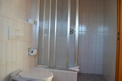 a room with a bed and a table and a chair at Pension Sonnalp in Ortisei