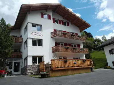 a bathroom with a sink and a toilet and a window at Pension Sonnalp in Ortisei