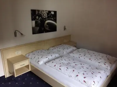 a bed in a room with a picture on the wall at Pension Sonnalp in Ortisei