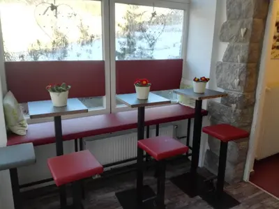 a bar with two stools and two windows at Pension Sonnalp in Ortisei
