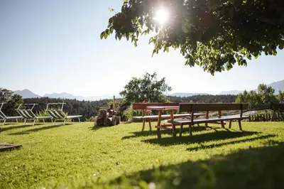 a group of picnic tables and chairs in the grass at Platterhof in Avelengo
