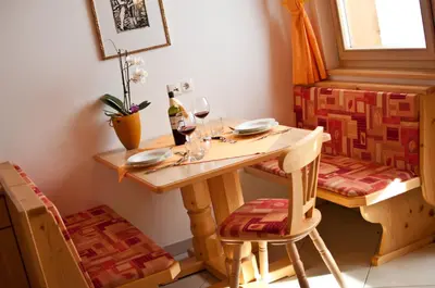 a table with a bottle of wine and two glasses at Platterhof in Avelengo