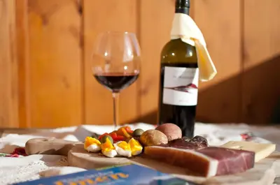 a bottle of wine and a glass of red wine at Platterhof in Avelengo