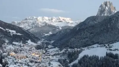 a snowy mountain range with a town and a city at apartment center pepi in Ortisei