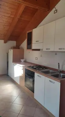 a kitchen with white cabinets and a sink and a stove at Appartamento vacanza Coredo Trentino in Coredo