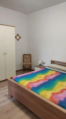 a bed with a colorful blanket on it in a room at Appartamento vacanza Coredo Trentino in Coredo