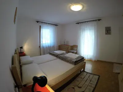 a bedroom with a large white bed and a window at Majon Di Roces in Canazei