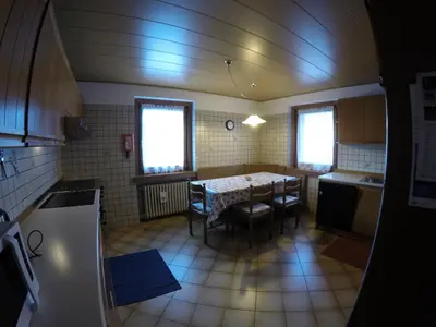 a kitchen with a table and chairs in a room at Majon Di Roces in Canazei