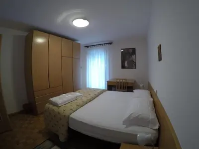 a bedroom with a bed and a cabinet and a table at Majon Di Roces in Canazei