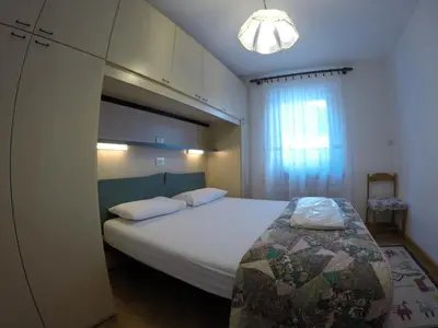a bedroom with a large white bed and a window at Majon Di Roces in Canazei